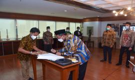Direktur Pengendalian SDPPI Sabirin Mochtar menandatangani Berita Acara Pelantikan Pejabat Fungsional Pengendali Frekuensi Radio Tingkat Keahlian, Rabu (17/02/2021).