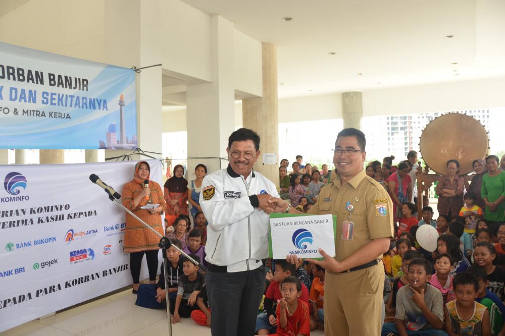 Menteri Komunikasi dan Informatika Jhonny G. Plate menyerahkan sumbangan Komunitas Kominfo kepada pihak perwakilan Kecamatan Kali Deres, Tangerang di lokasi pengungsian di Mesjid Raya KH. Hasyim Asyhari, Jakarta Barat (7/01/2020).